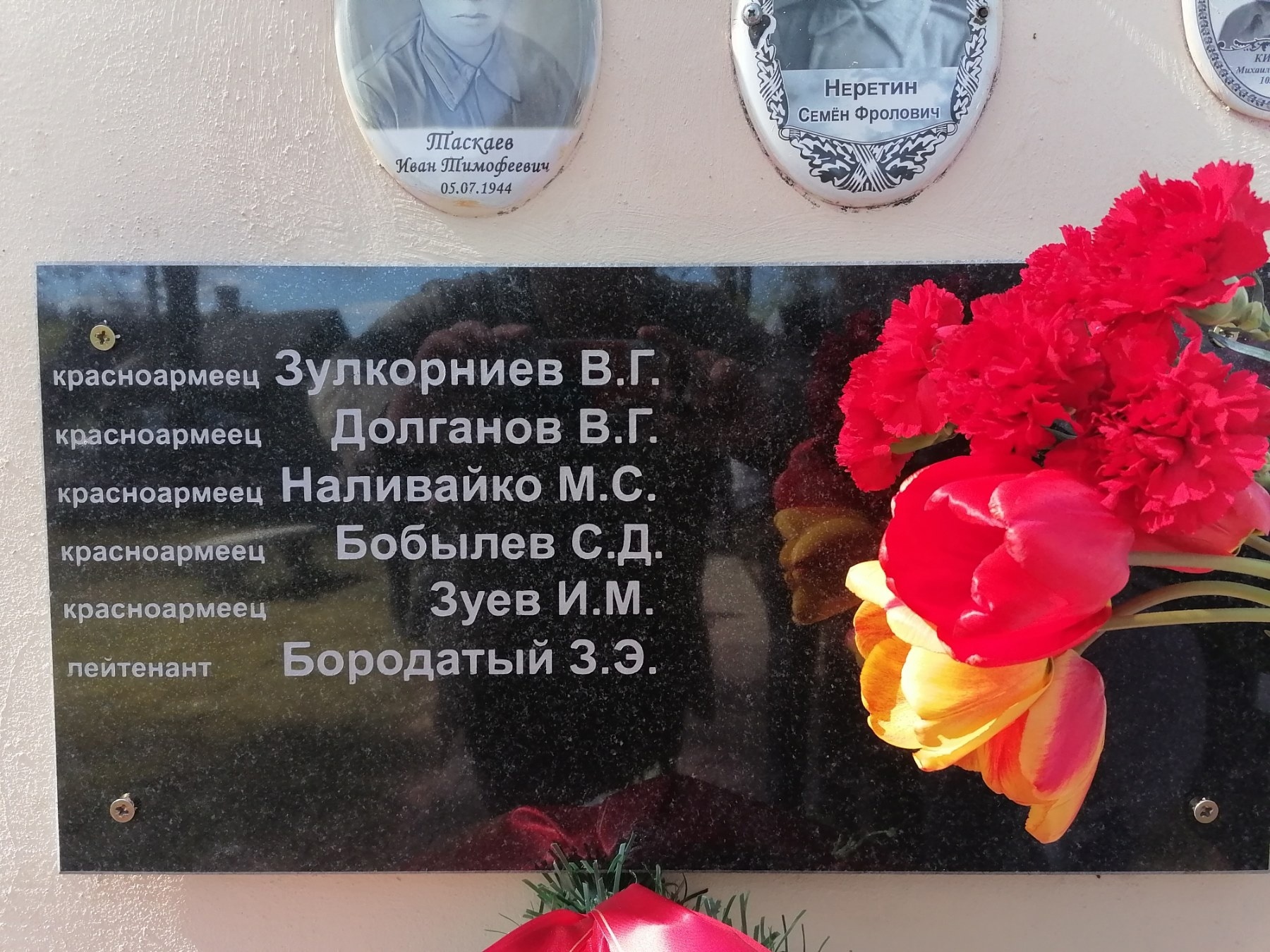 Новые имена погибших солдат выбиты на мемориальной плите на братской могиле в Леонполе
