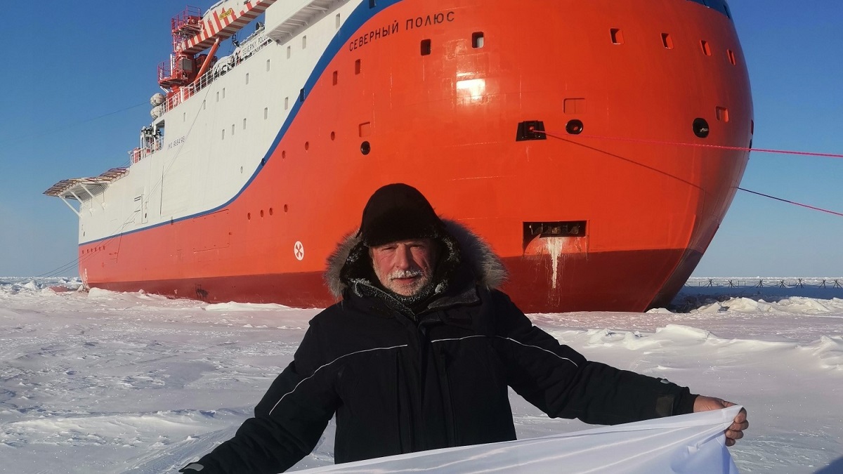 Ведущий океанолог Мирового центра данных по морскому льду Томаш Петровский развернул флаг Глубокского района на Северном полюсе